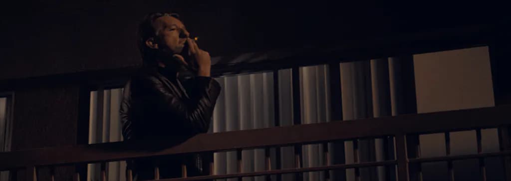 hombre fumando en un balcón