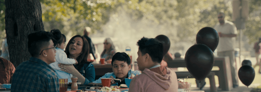 Families at a park surrounded by balloons