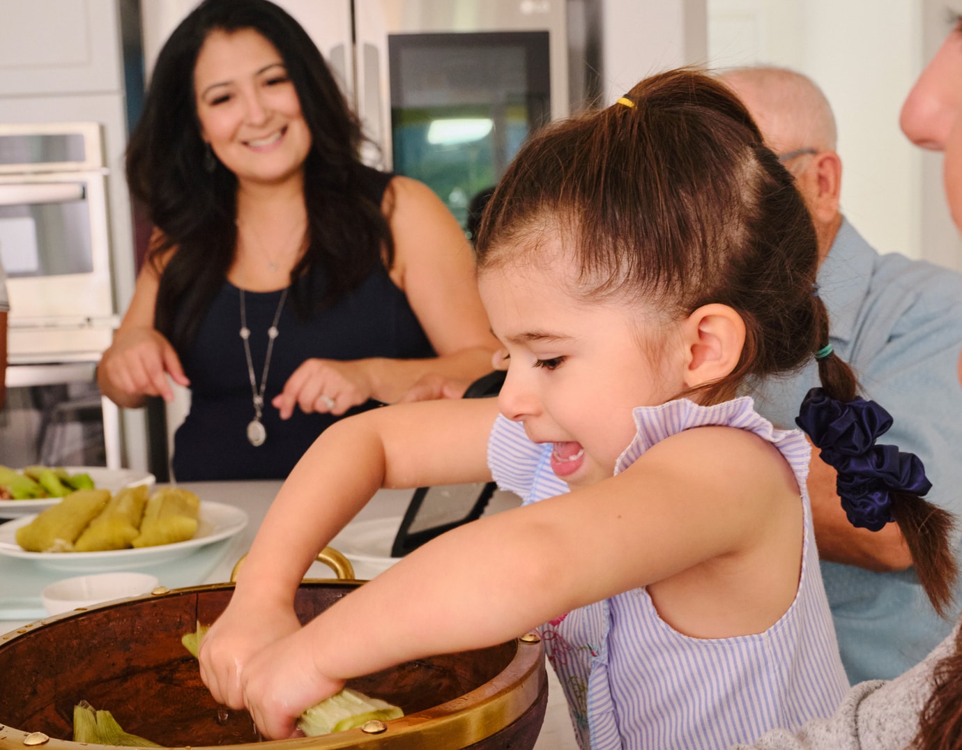 Niña haciendo tamales con su familia