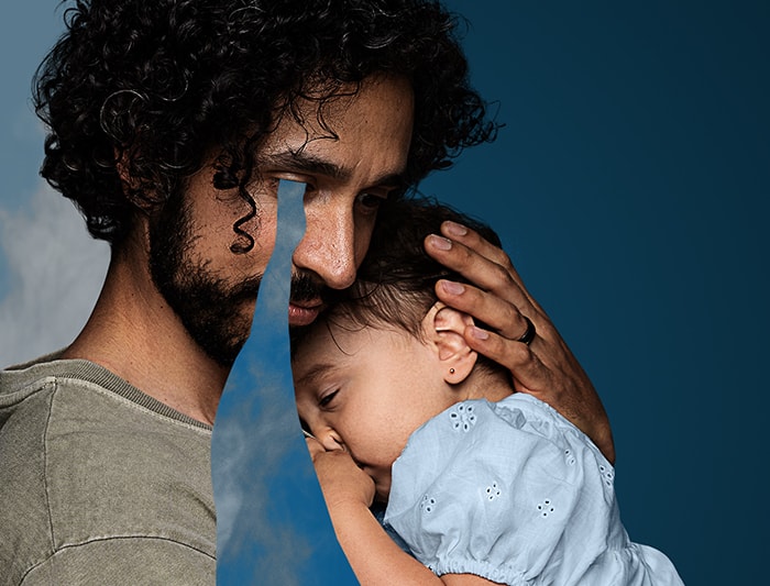 hombre llorando abrazando a su bebe