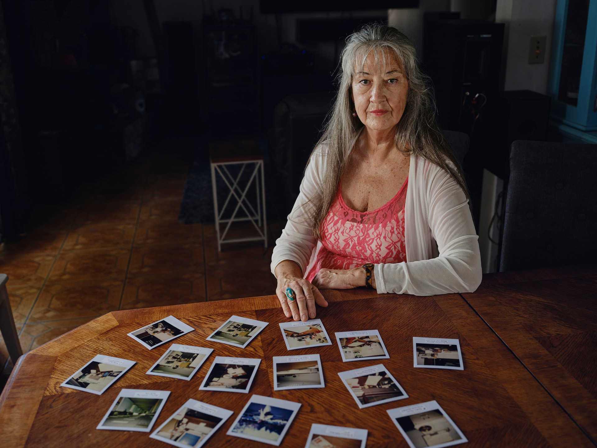 Una señora sentada en una mesa con fotos de cuando se fumaba en el trabajo