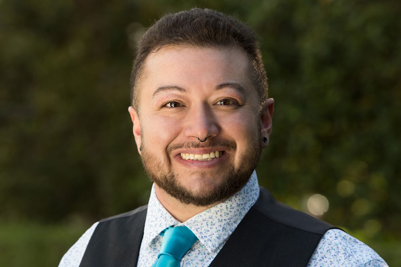 person smiling with blurred nature background
