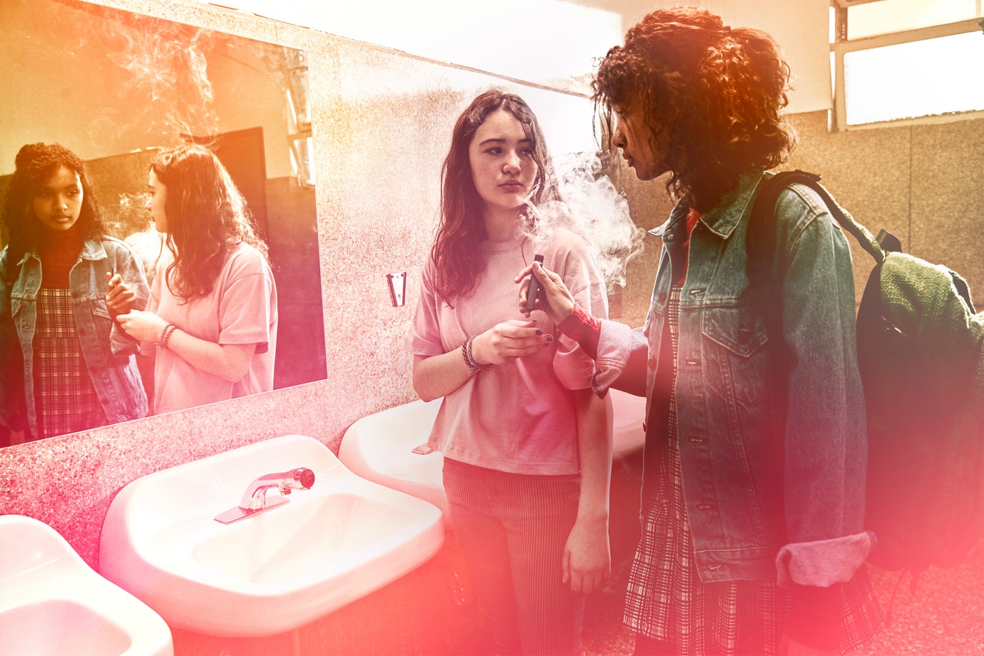Two young girls smoking a vape