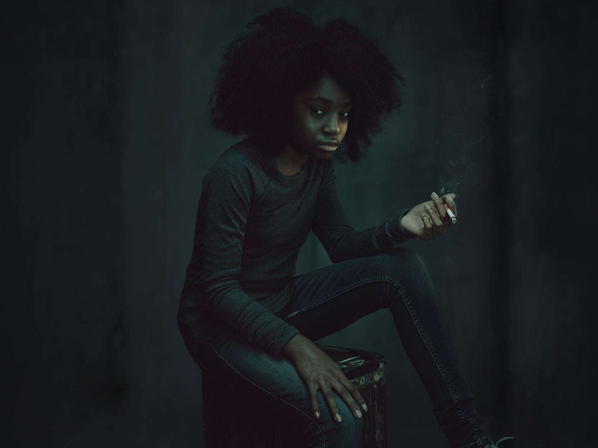 Woman sitting and holding a cigarette