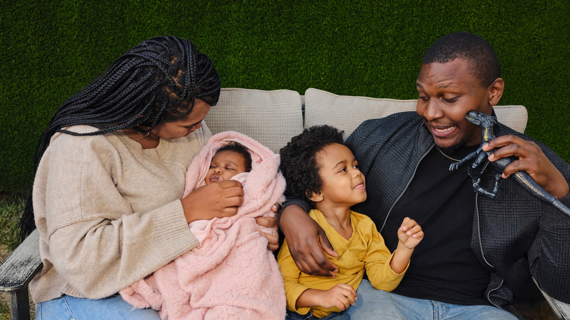 Family sat on a couch with two young children