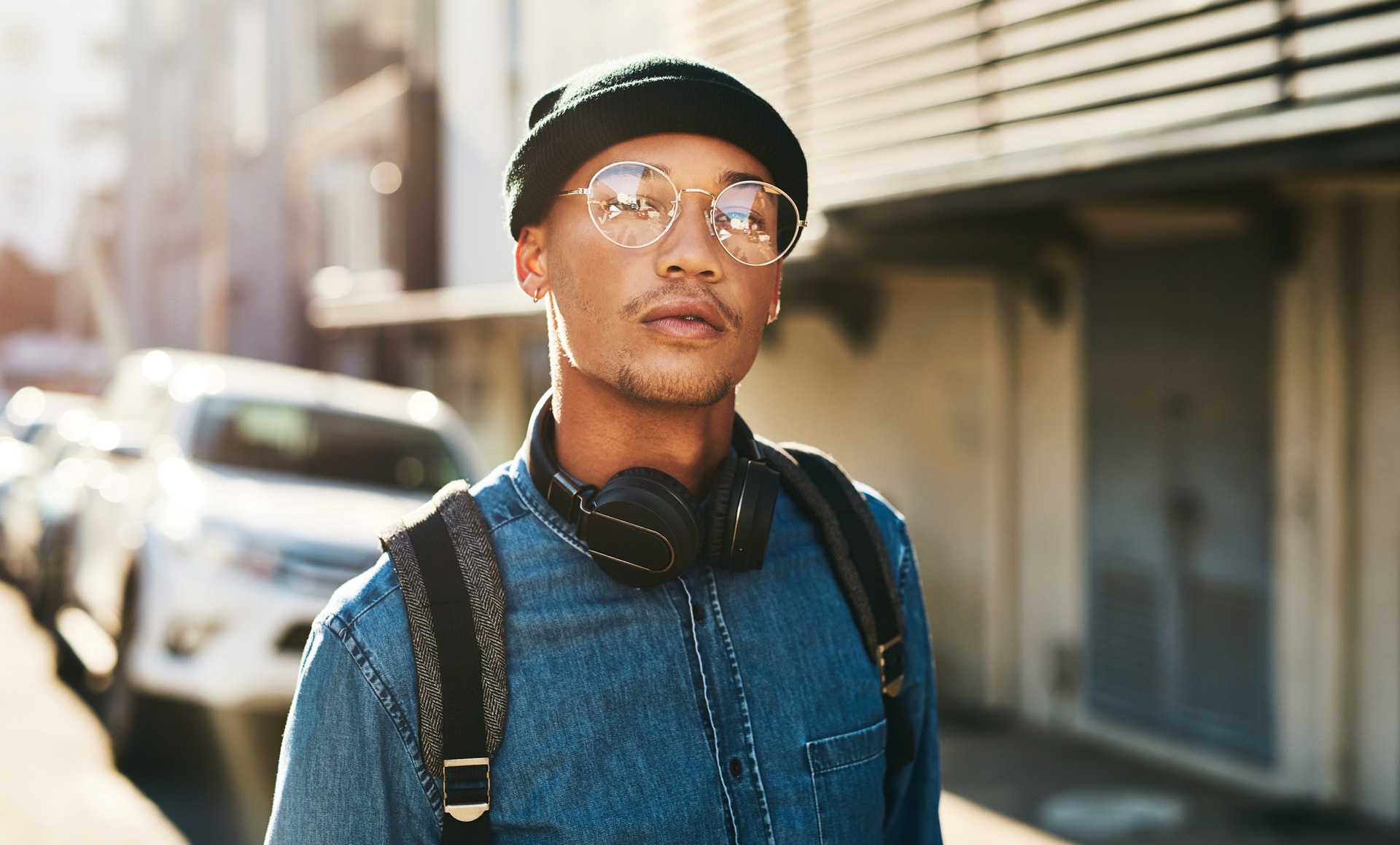 young man with glasses on a city street