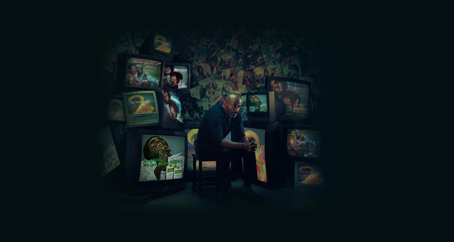 An African American/Black man sitting on a chair watching cigarette ads