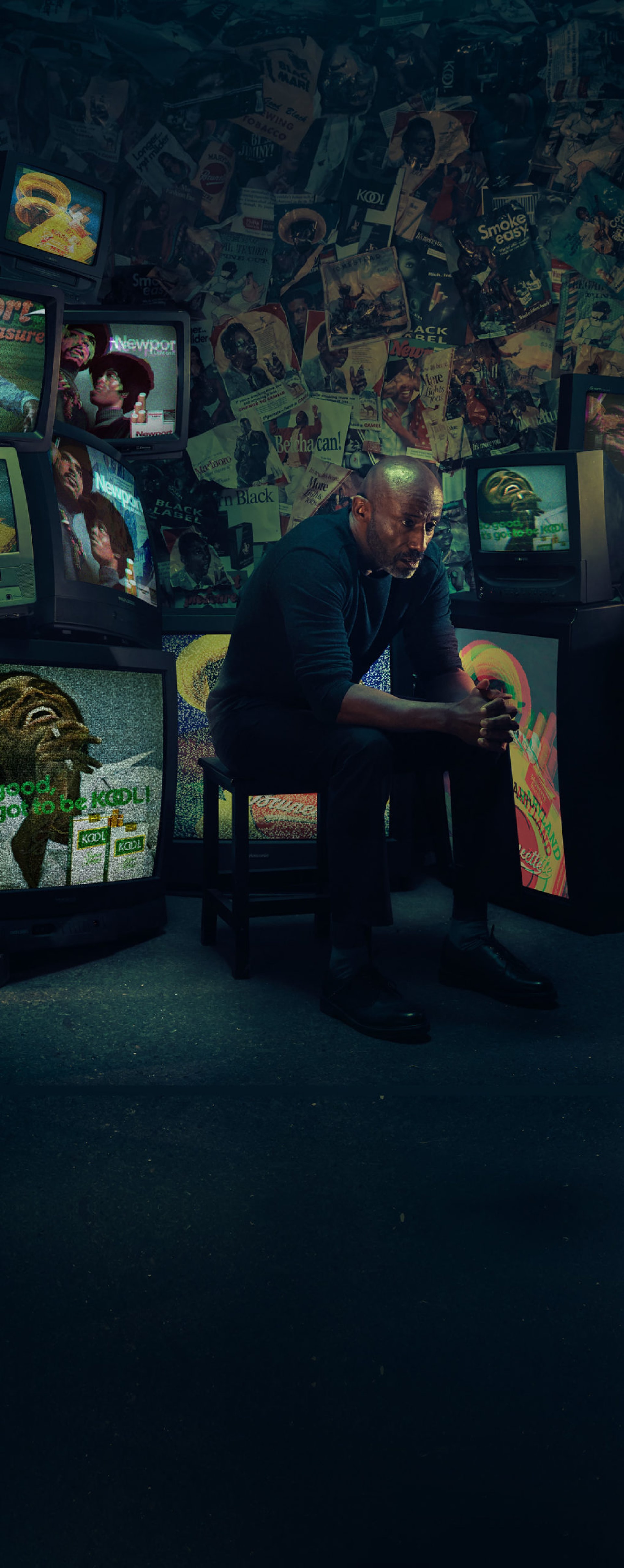 An African American/Black man sitting down in a light background