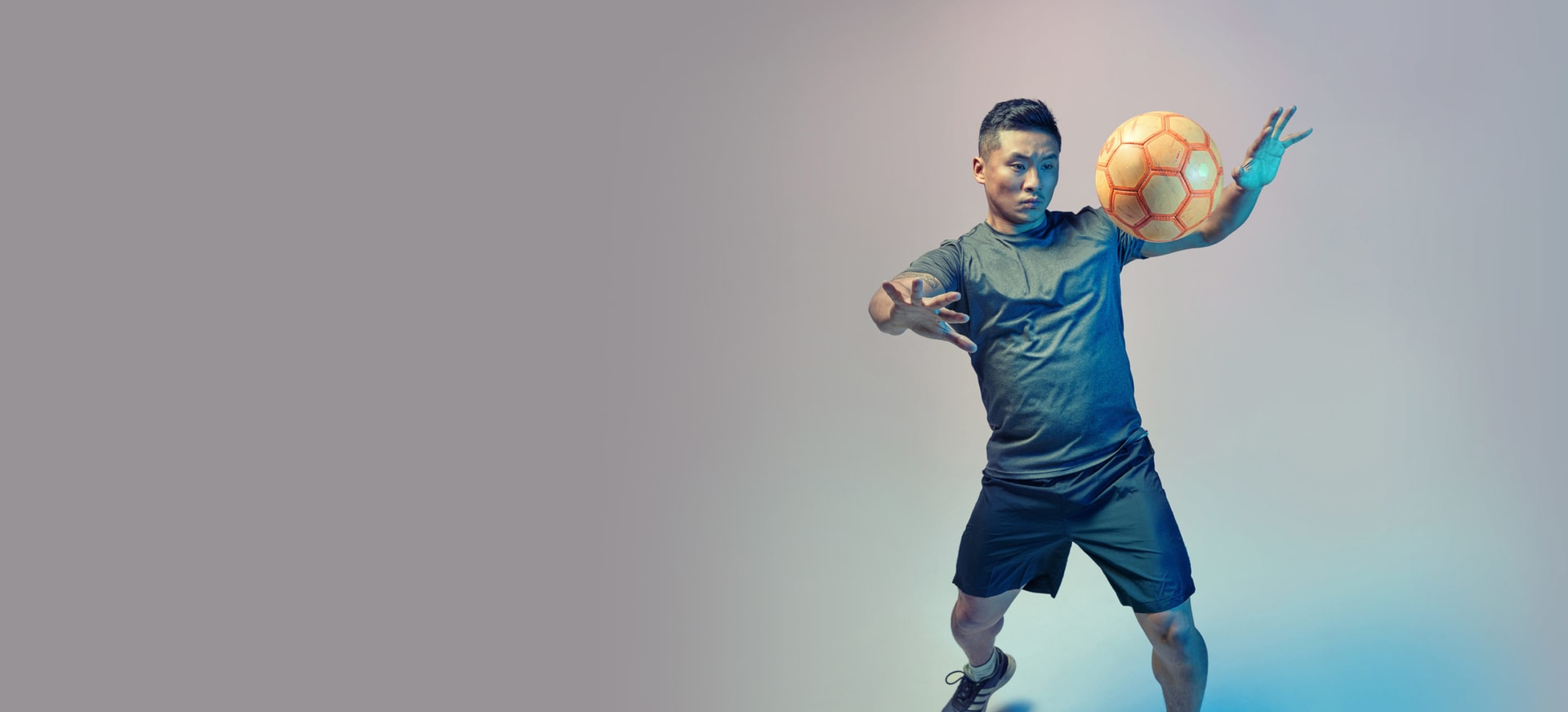 An Asian/Pacific Islander man playing with soccer ball