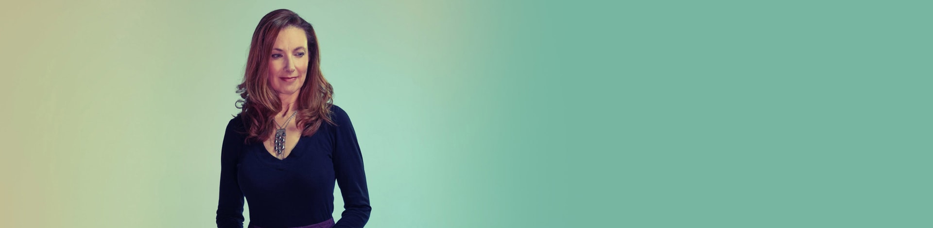 A woman slightly smiling in a light background