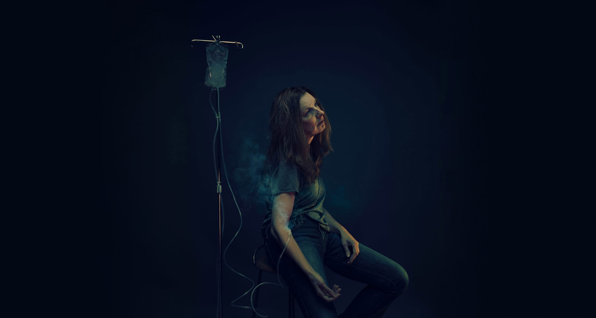 Man in dark background with smoke around face