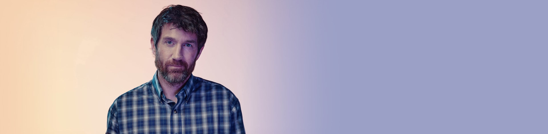 Man in light background slightly smiling