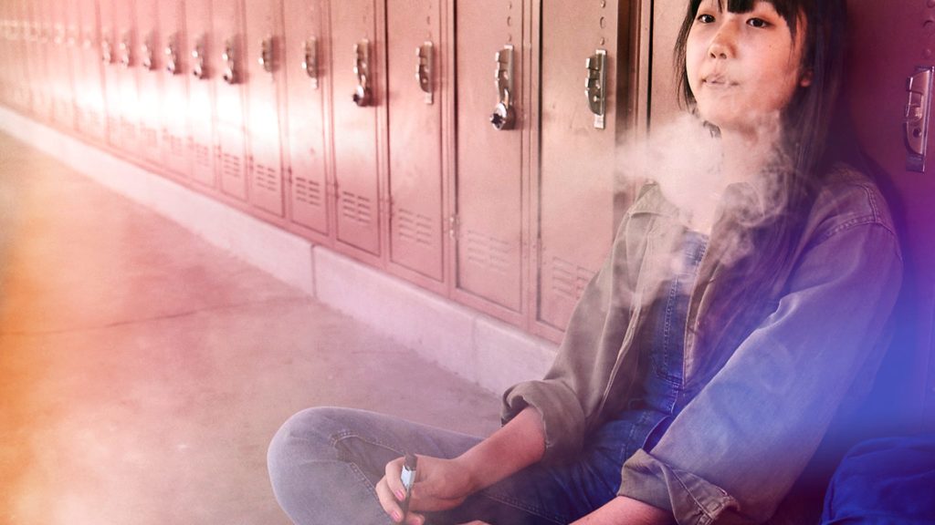 girl vaping next to school lockers