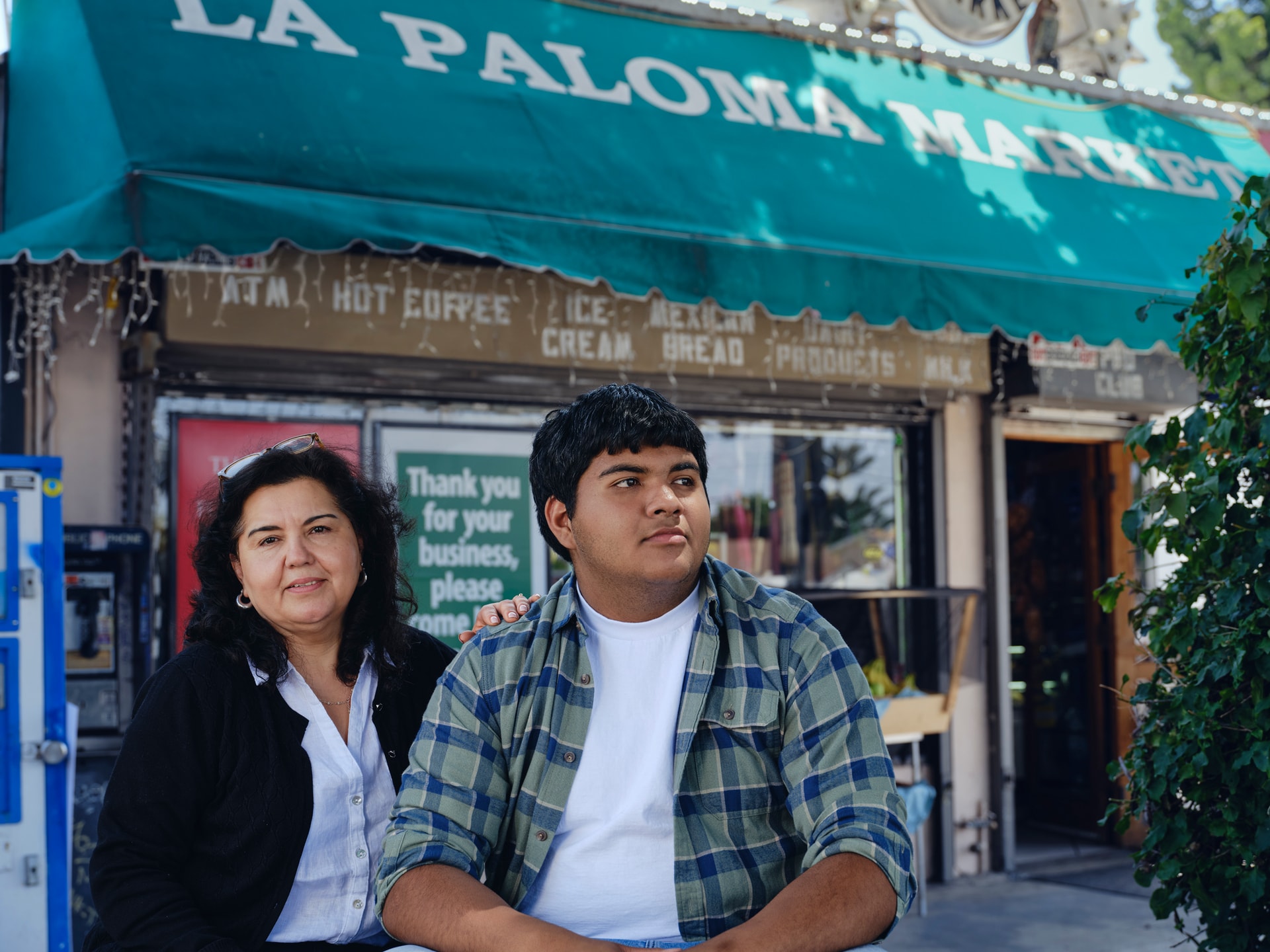 Maria and her son stand in front of La Paloma Market, where they have stopped selling vapes