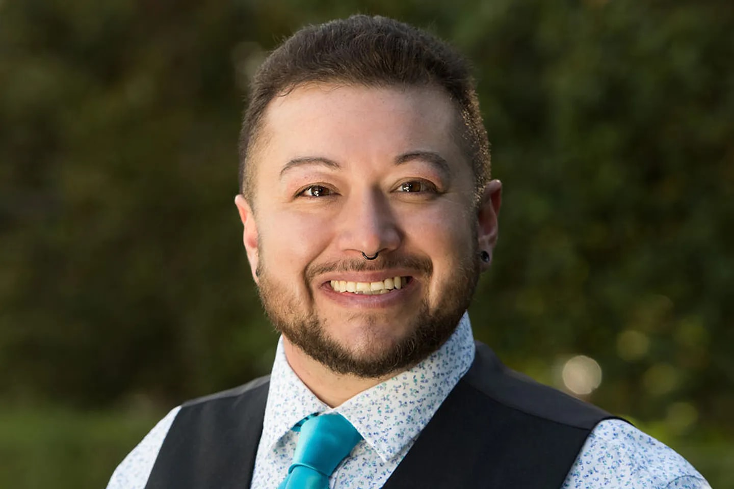 person smiling with blurred nature background