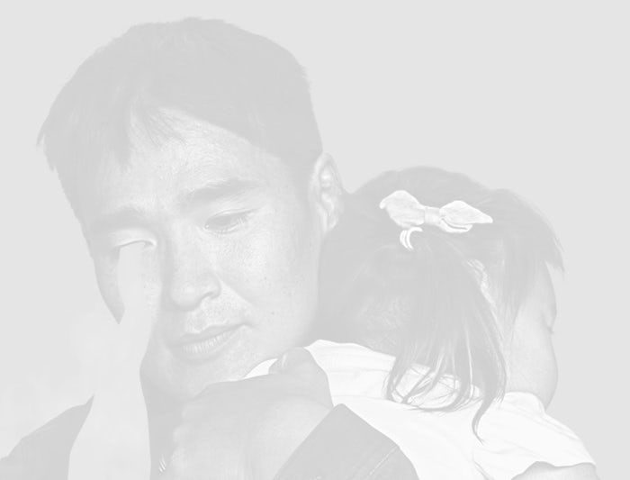 A black and white portrait of a man holding his child - asian