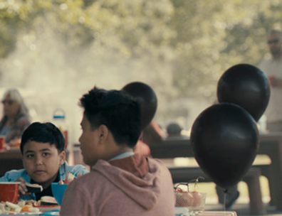 Families at a park surrounded by balloons