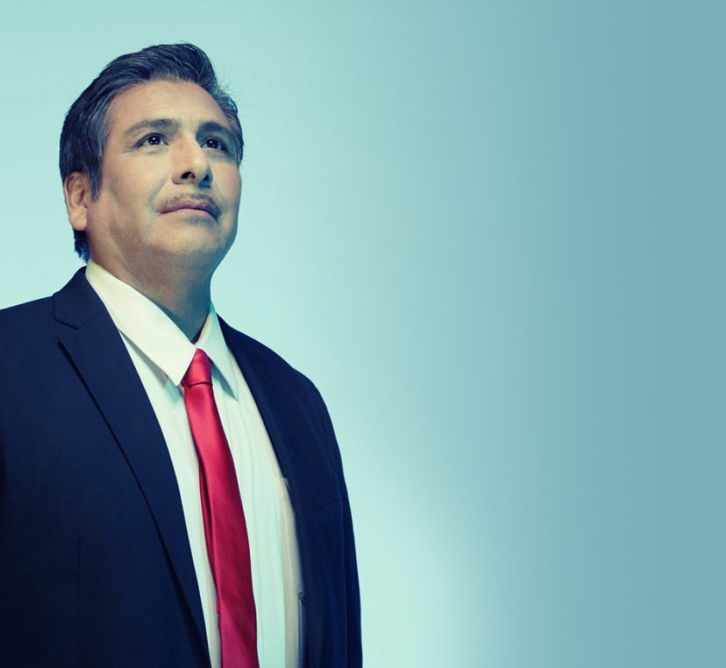 A Hispanic/Latino man in a suit looking up