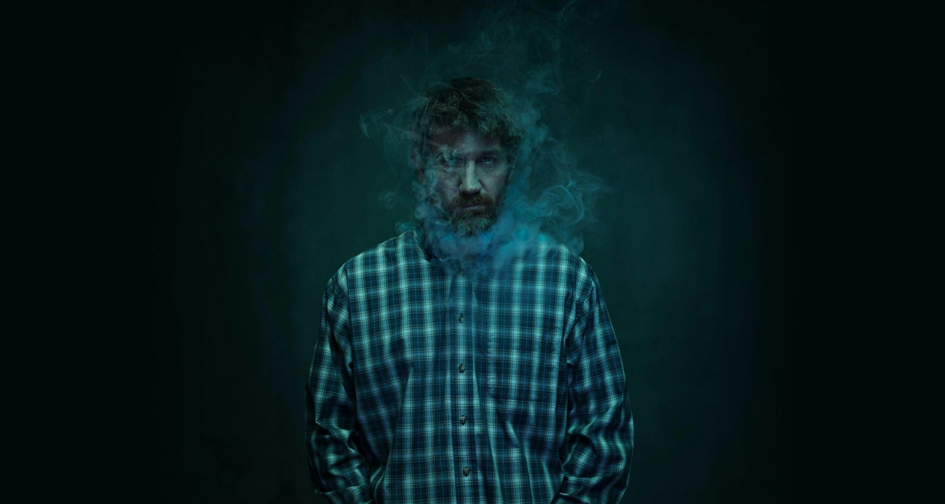 Man in dark background with smoke around his face